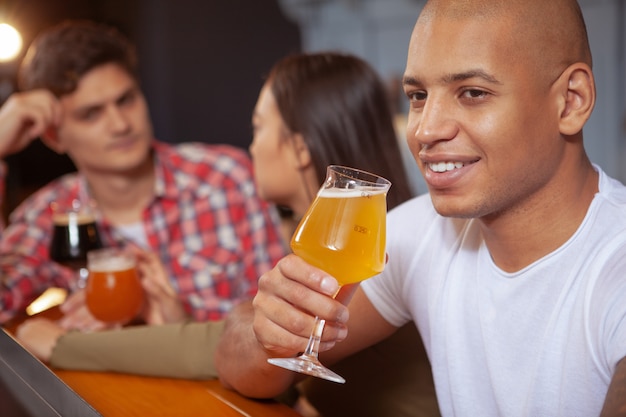 Diverse groep vrienden die bier drinken samen in de kroeg