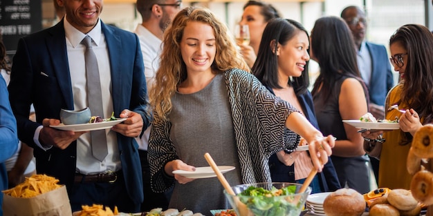 ブッフェで食べ物を楽しむ多様なグループ 笑顔でおしゃべりしている人々 共に食事を楽しんでいる多様な個人とのブッフェ環境 昼食のブッフェで多様な人々