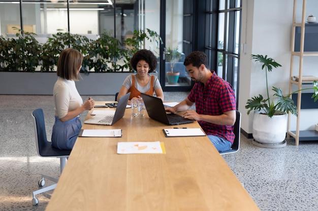 Photo diverse group of business people working in creative office. group of people sitting and discussing work. business people and work colleagues at a busy creative office.