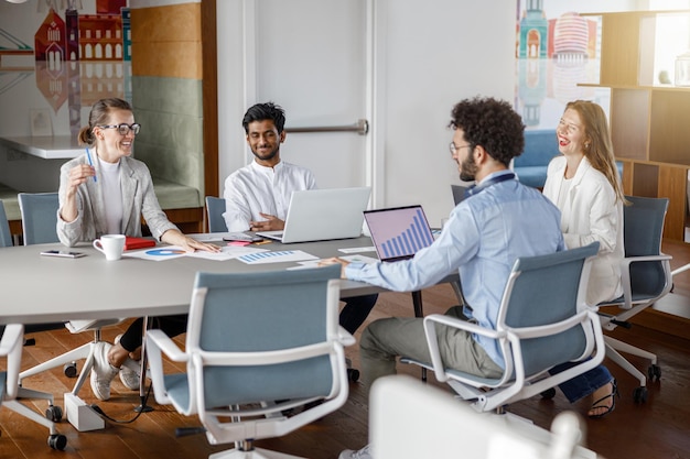 Foto gruppo eterogeneo di colleghi che si divertono a lavorare insieme in un concetto di lavoro di squadra in ufficio