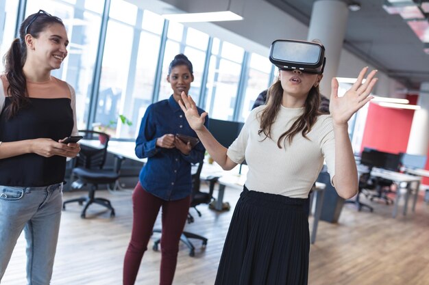 Diverse group of creative colleagues talking at meeting using vr headset. modern office of a creative design business.