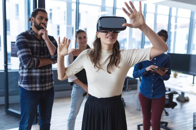 Diverse group of creative colleagues talking at meeting using vr headset. modern office of a creative design business.