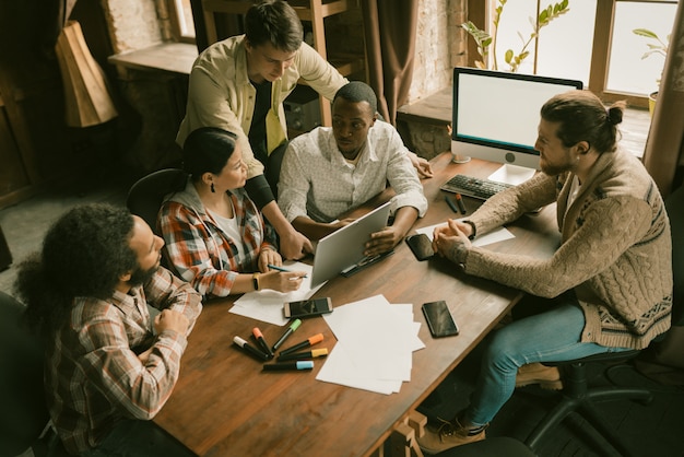 Gruppo eterogeneo di liberi professionisti brainstorming nel coworking