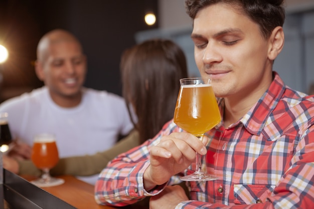 Diverse group of friends drinking beer at the pub together