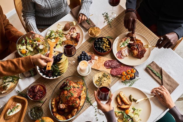 Diverse group of friends enjoying homemade food at festive dinner table