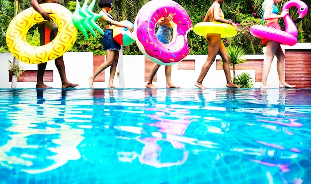 インフレータブルフロート付きプールで夏の時間を楽しむ様々なグループの友達