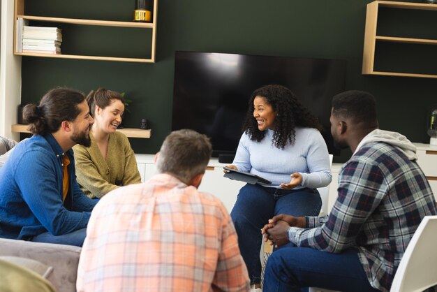 Photo diverse group of friends and female therapist with tablet in group therapy session