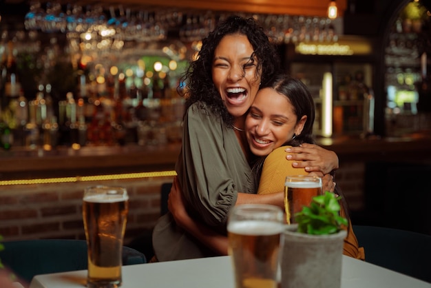 Diverse group of friends out for dinner saying hello and\
embracing