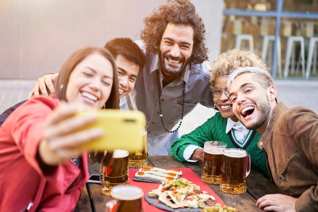 Diversi gruppi di amici che si fanno un selfie a una festa all'aperto