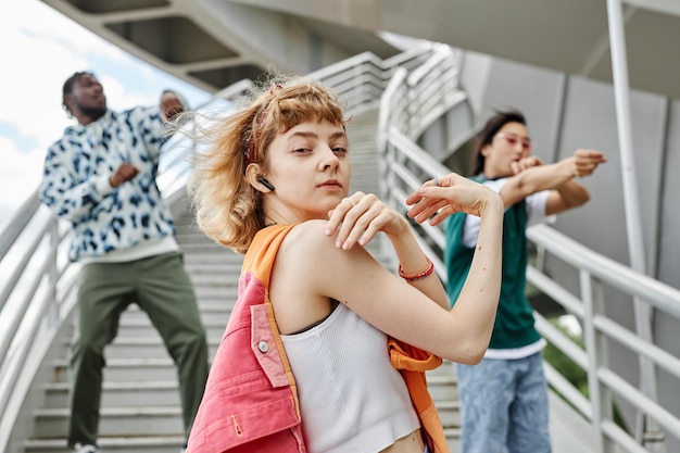 写真 都市の設定で屋外で踊るカラフルな服を着ている人々 の多様なグループ