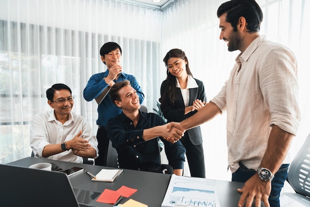 Diverse group of office employee worker shake hand after making agreement on strategic business marketing meeting Teamwork and positive attitude create productive and supportive workplace Prudent