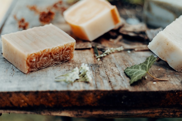 Diverse handgemaakte natuurzepen op een vintage houten tafel met decoratie