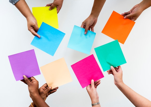 Photo diverse hands holding colourful square paper