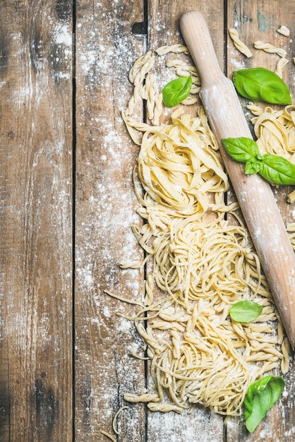 Diverse huisgemaakte verse ongekookte Italiaanse pasta met meelbasilicum