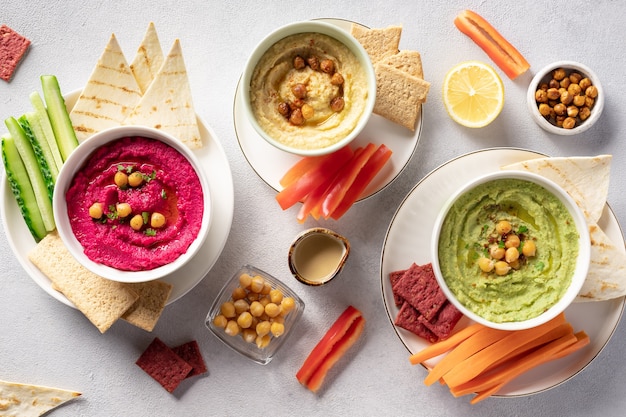 Diverse hummus dips in kom, geserveerd met verse groenten