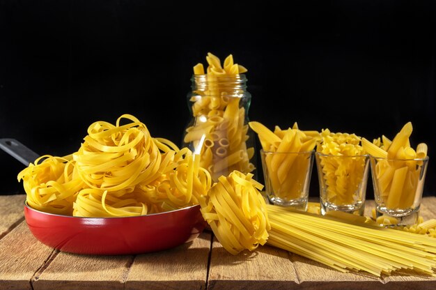 Diverse ingrediënten voor spaghetti bolognese op houten achtergrond, voedsel en kok concept