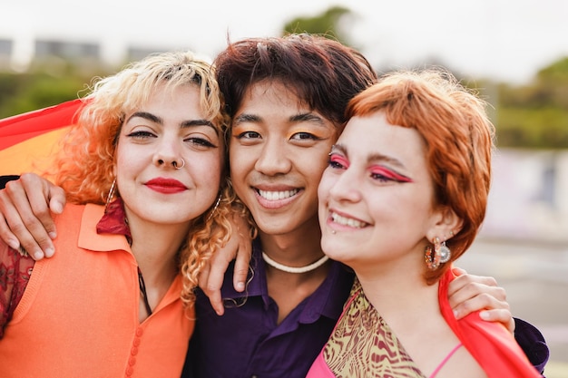 Diverse jonge mensen die plezier hebben tijdens de lgbt-trotsparade terwijl ze glimlachen voor de camera