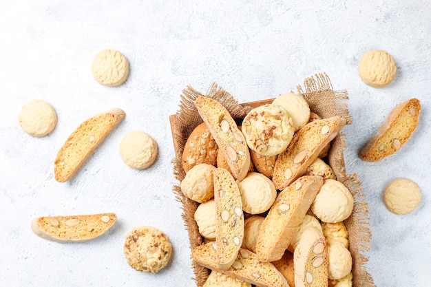 Diverse koekjes in een houten dienblad op grijs