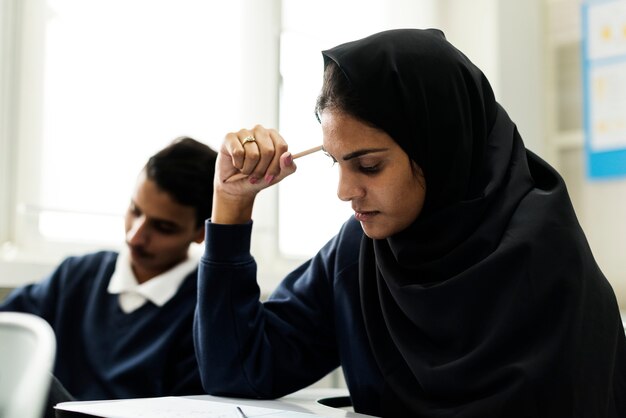 diverse moslimkinderen die in klaslokaal bestuderen