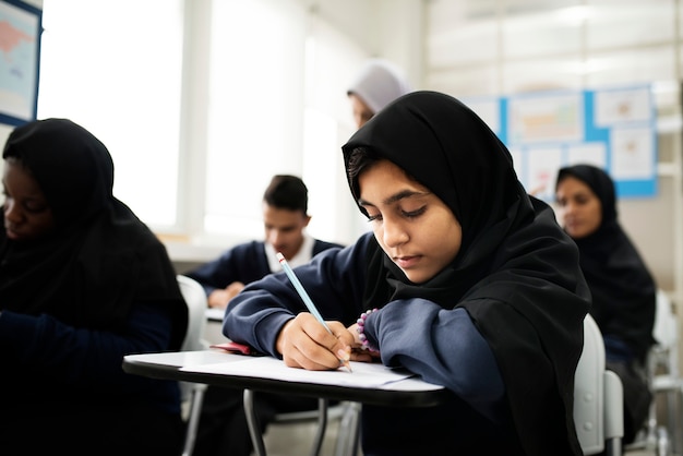 diverse muslim children studying in classroom