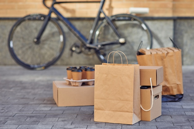 Diverse pakketten met pizzadozen voor eten en vier koffiekopjes die op straat staan
