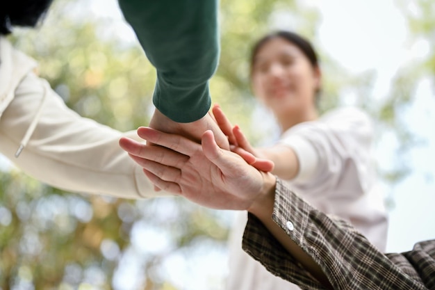 Diverse persone uniscono le mani per rallegrare la celebrazione dell'amicizia giovanile