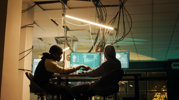 diverse people using trojan virus to exploit server vulnerability, hacking computer system late at night. cyber criminals working with encryption to hack software and break security firewall.