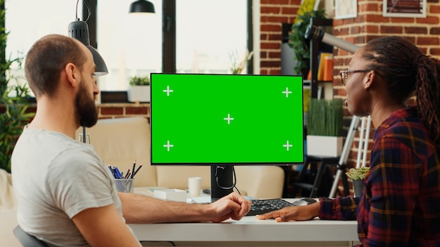 Diverse people working with greenscreen monitor on computer,
analyzing isolated chroma key on blank background. planning
teamwork at home office desk using mockup copyspace template.