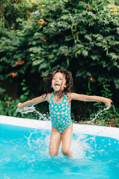 Foto diverse peuter kleuterschool meisje thuis tijdens een hete zomerdag plezier in het kinderzwembad