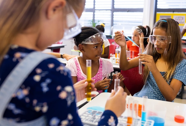 Foto diverse schoolmeisjes met chemische artikelen en vloeistoffen in de basisschoolklasse