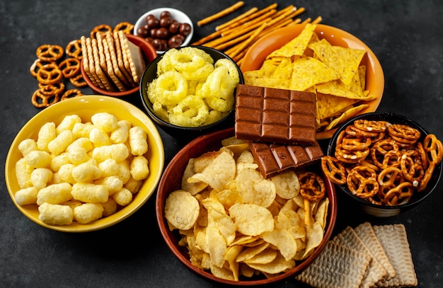 Foto diverse snacks en chocolade op een zwarte tafel