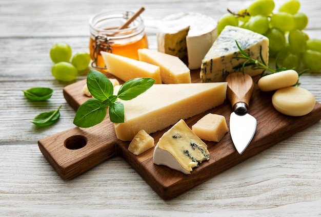Diverse soorten kaas op een witte houten achtergrond