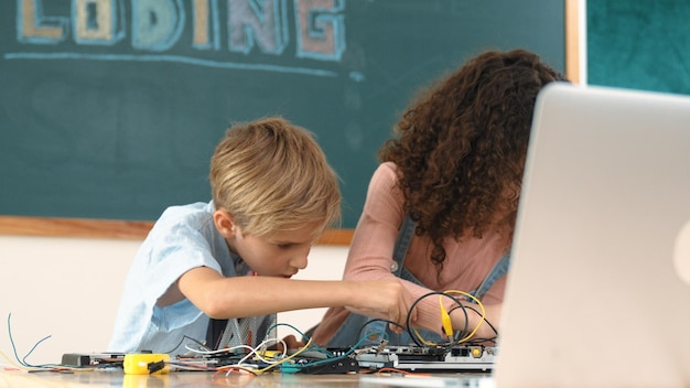 Photo diverse student working together to fix main board at stem class pedagogy