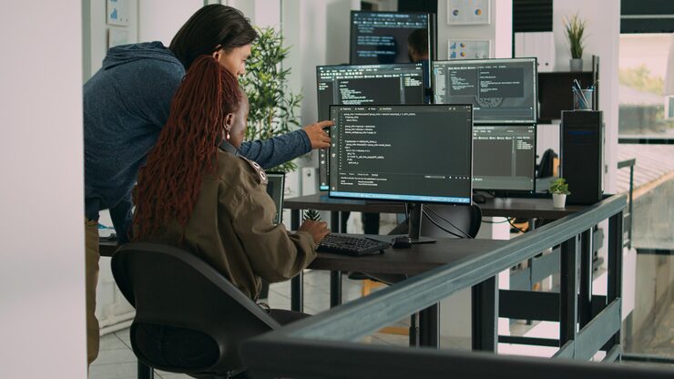Photo diverse team of ai cloud programers talking about coding script in front of computer, working on server interface development. programmers doing teamwork to plan html software language.