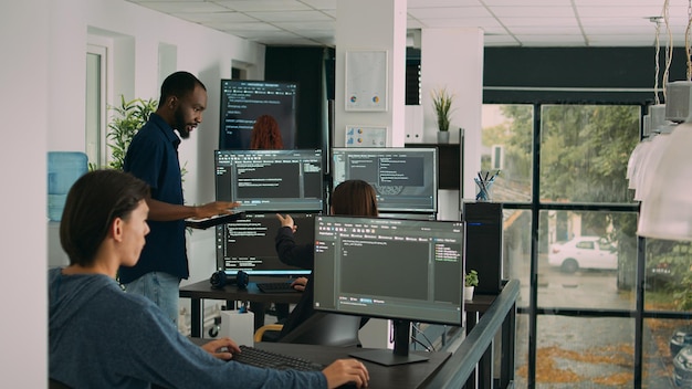 Diverse team of database developers analyzing code on terminal
window, working with html script and artificial intelligence.
system engineers talking about app developing interface.