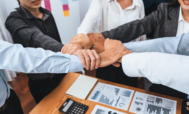 Diverse team of officer worker hold hand in circle at corporate office Concord