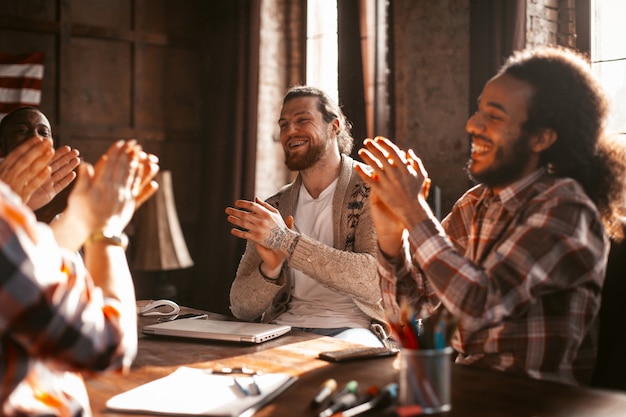 Photo diverse team of partners applauds each other in office