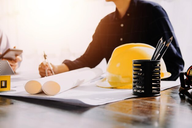 Foto diversi team di specialisti utilizzano il computer tablet sul progetto di costruzione di immobili in cantiere con ingegnere civile, architetto, investitore aziendale e lavoratore generale, discutendo i dettagli del piano