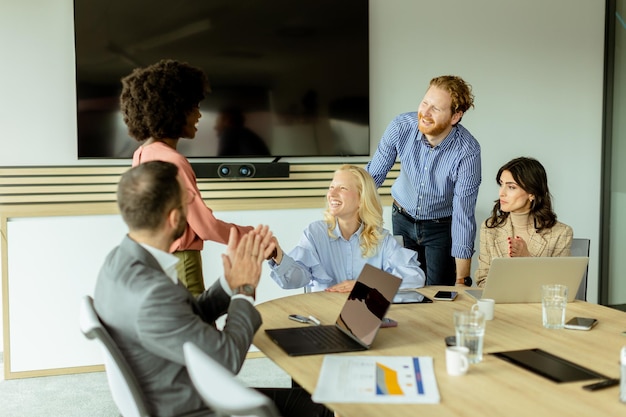 Foto diverse teams die samenwerken tijdens een creatieve kantoorvergadering om de middag