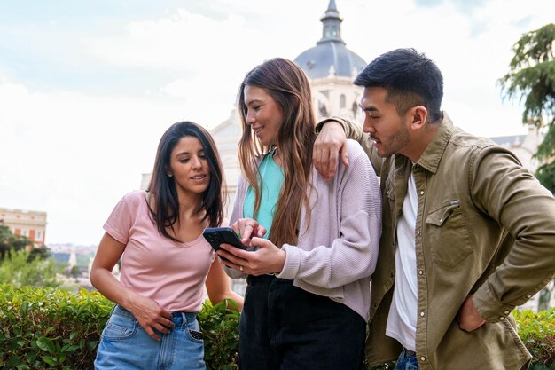 Diverse Trio Embracing Adventure Joyful Young Tourists at Park with Historic Monument