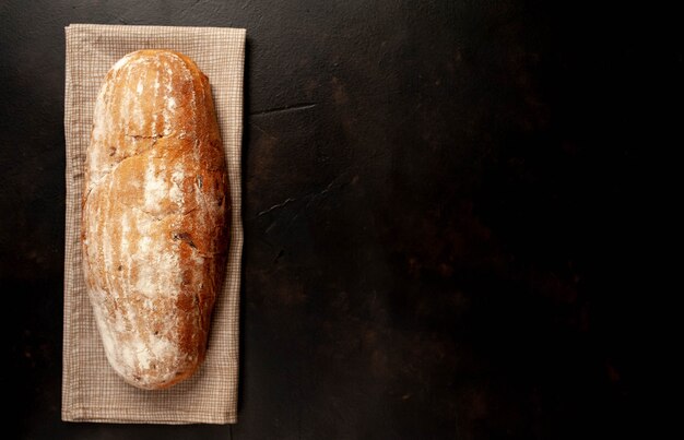 Diverse vers brood en broodjes op een stenen tafel.