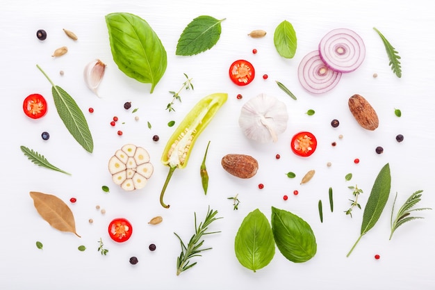 Diverse verse kruiden voor het koken van ingrediens op witte houten achtergrond met vlakte leggen.