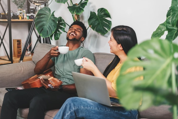 Foto diverse vrienden afro-amerikaanse en aziatische vrouw praten samen met gelukkig in de woonkamer