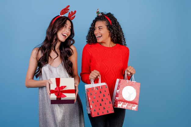 Diverse vrouwen met geschenkdoos en geschenken in boodschappentassen