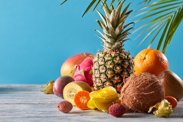 Diverse vruchten exotisch palmblad op een grijze houten tafel