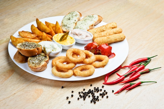 Diverse warme snacks. geroosterde kaas, croutons, uienringen met ketchup