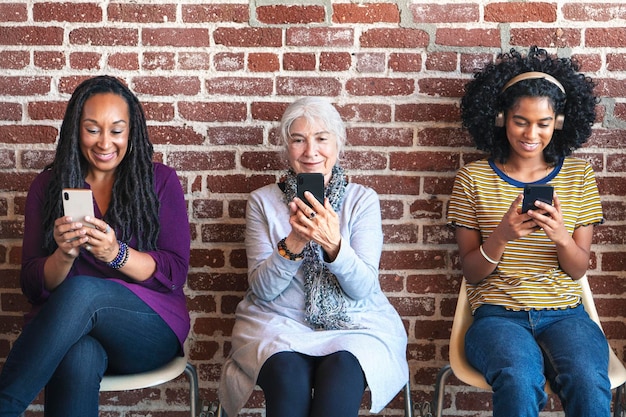 Photo diverse women concentrating on their phones