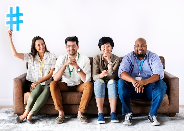 Diverse workers sitting together woman holding hashtag icon