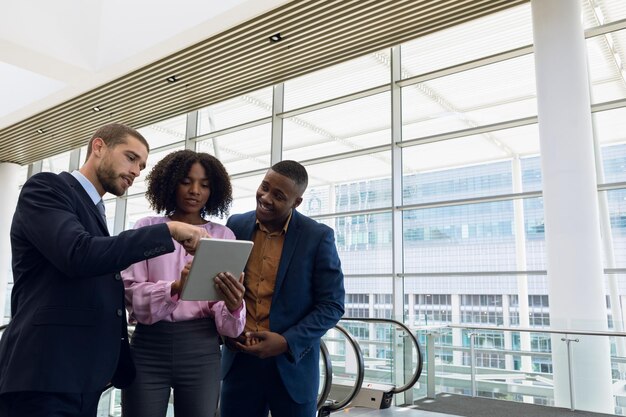 Photo diverse young business people using tablet in modern office lobby