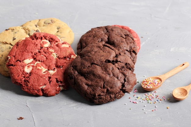Diverse zachte Amerikaanse koekjes vanille rood fluweel en donkere chocoladeschilfers op rustieke tafel